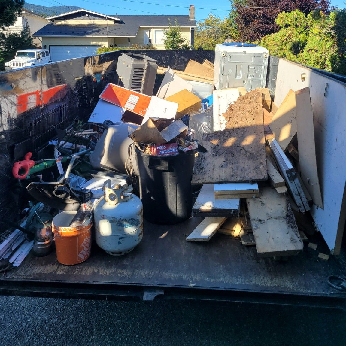 A real half load: appliances, lumber and household debris filling about half the Junk Matters trailer