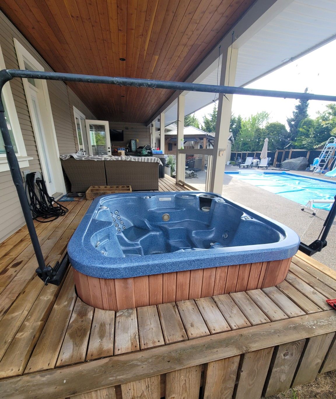 An old hot tub sitting on a backyard deck in Nanaimo before Junk Matters cut it down for removal