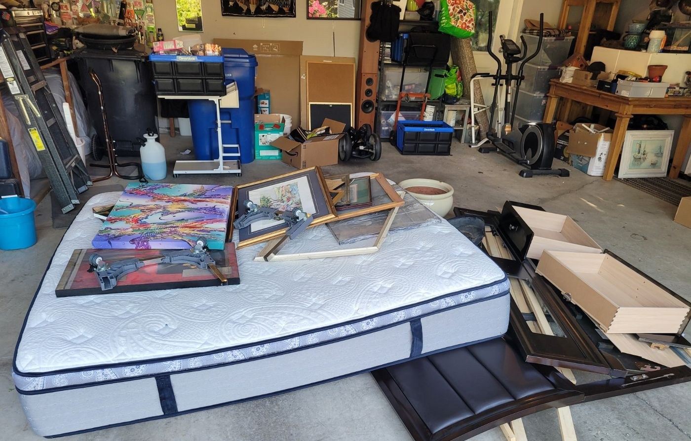A garage holding a mattress, framed art and exercise equipment before a Junk Matters cleanout in Nanaimo